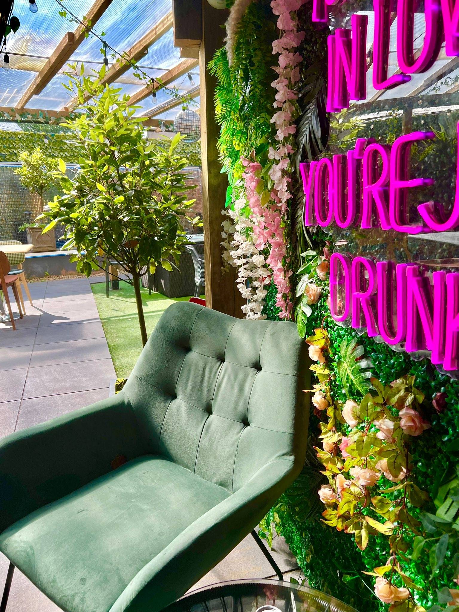 Sunlit garden seating and floral neon wall at Badavis Lounge